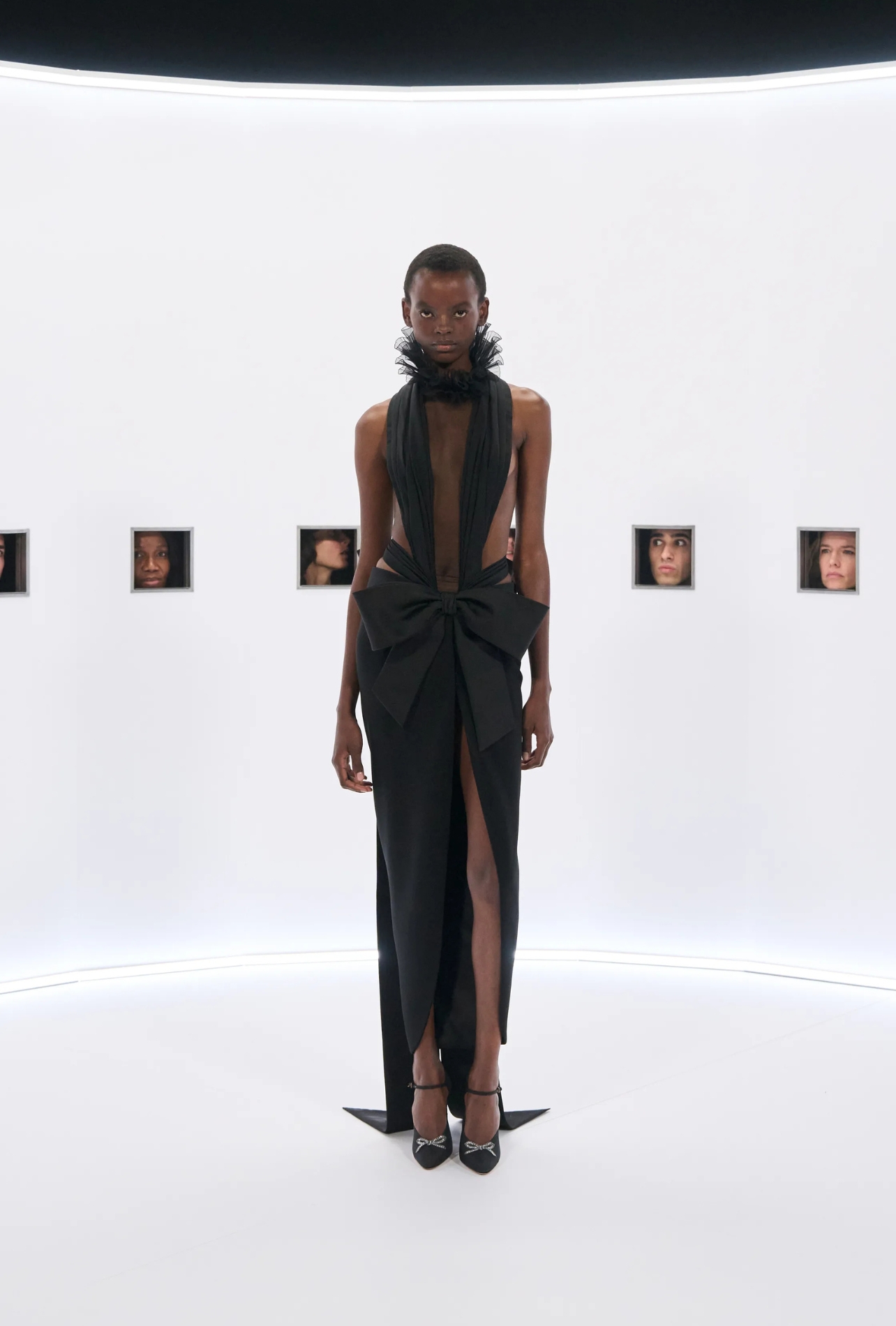 Valentino runway model wearing a black dress with a large bow