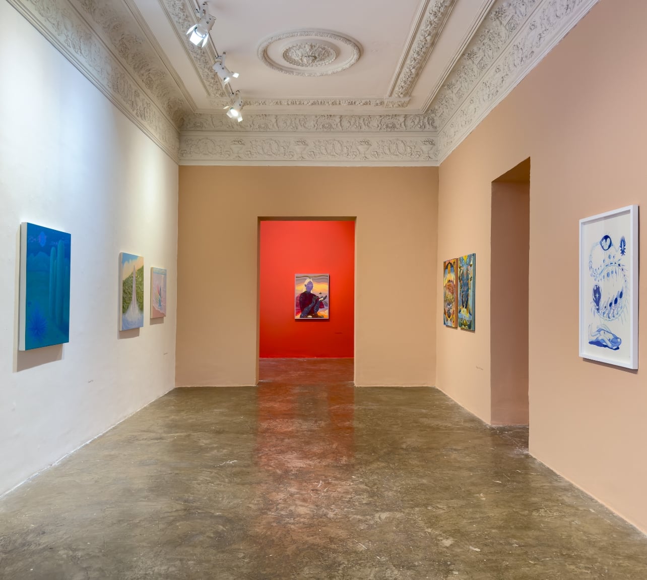 Interior of an art gallery with a red wall