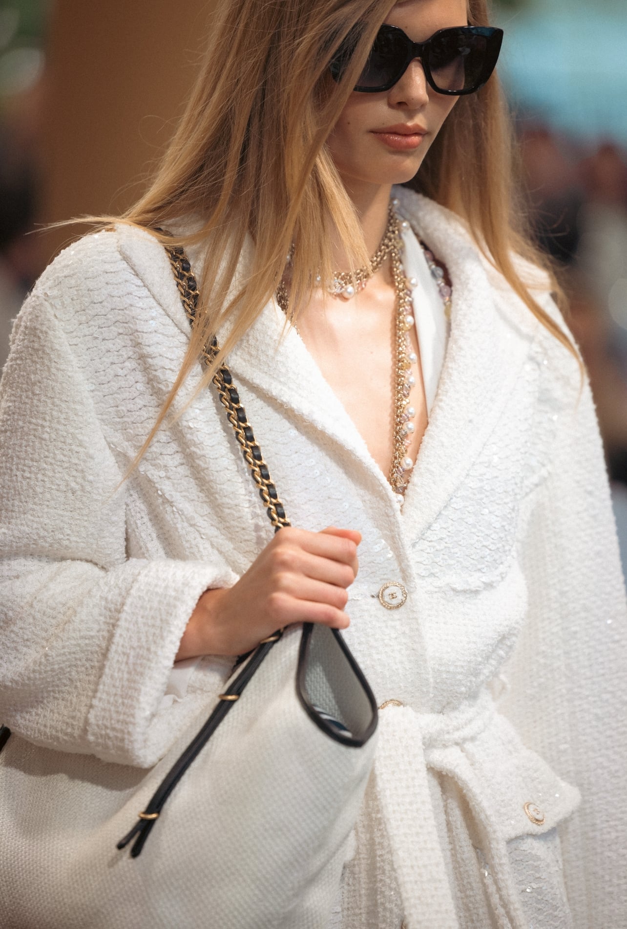 Chanel runway model wearing a pearl chain necklace and sunglasses