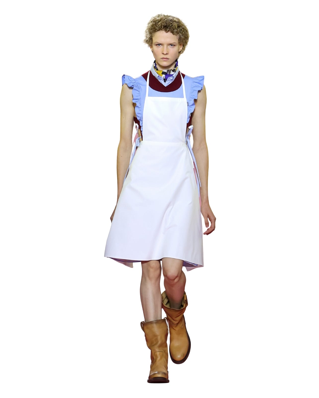 A Miu Miu runway model wearing a white apron paired with a ruffled sleeveless top