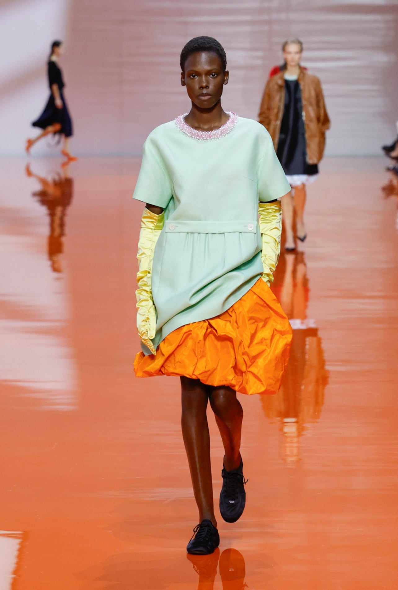 Prada runway model wearing a mint dress yellow gloves
