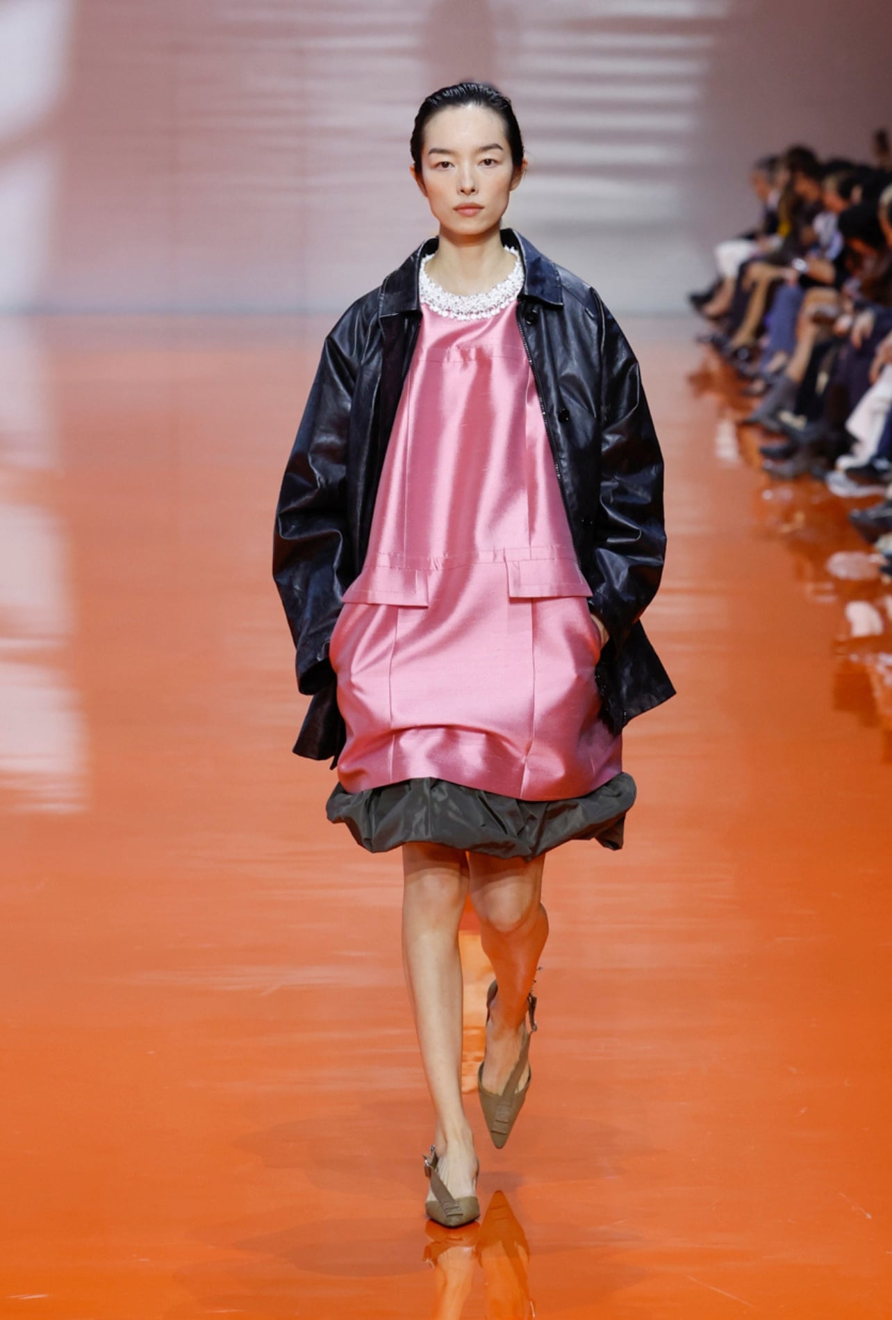 Prada runway model wearing a pink dress black jacket