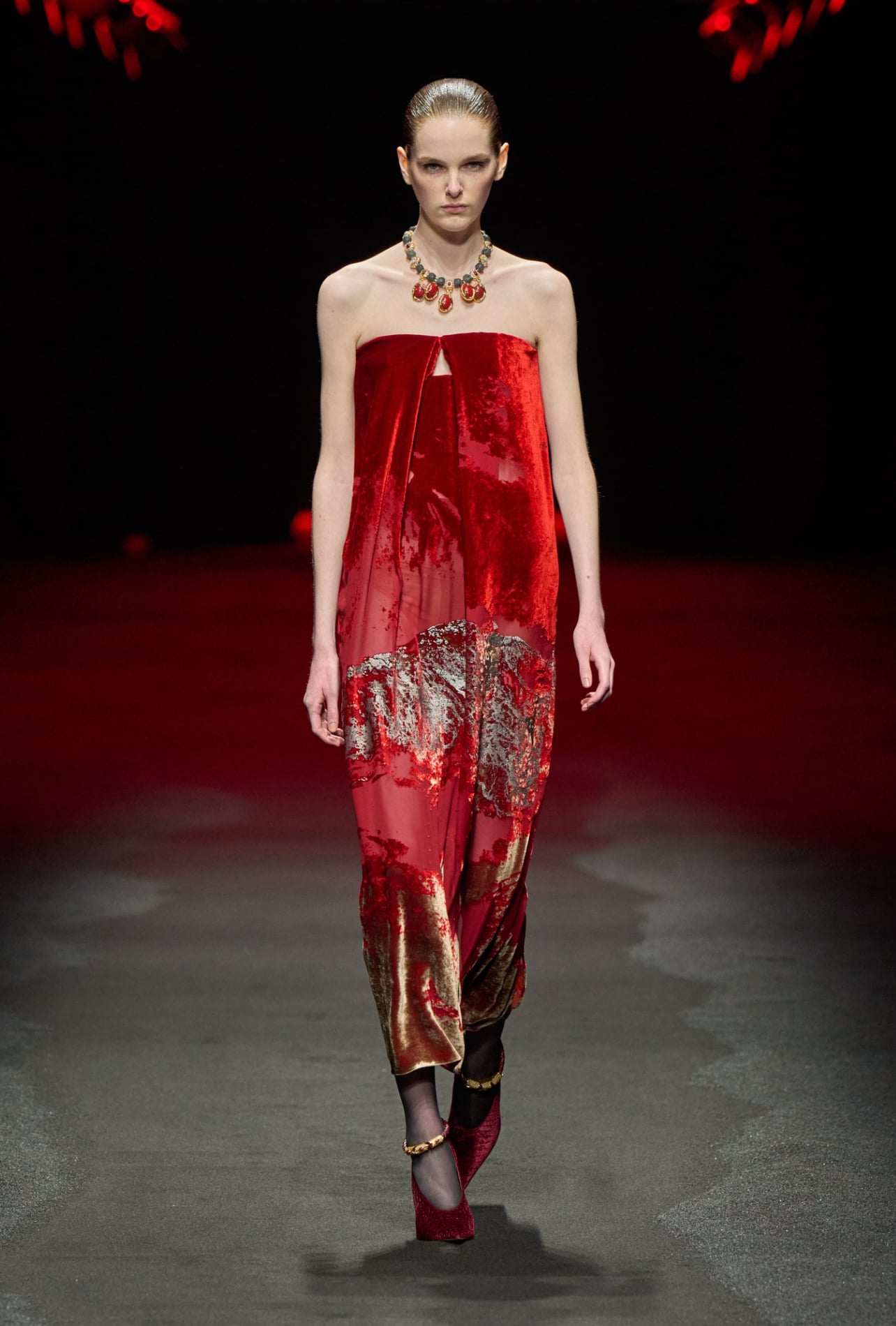 Roberto Cavalli runway model wearing a red dress with gold and silver accents