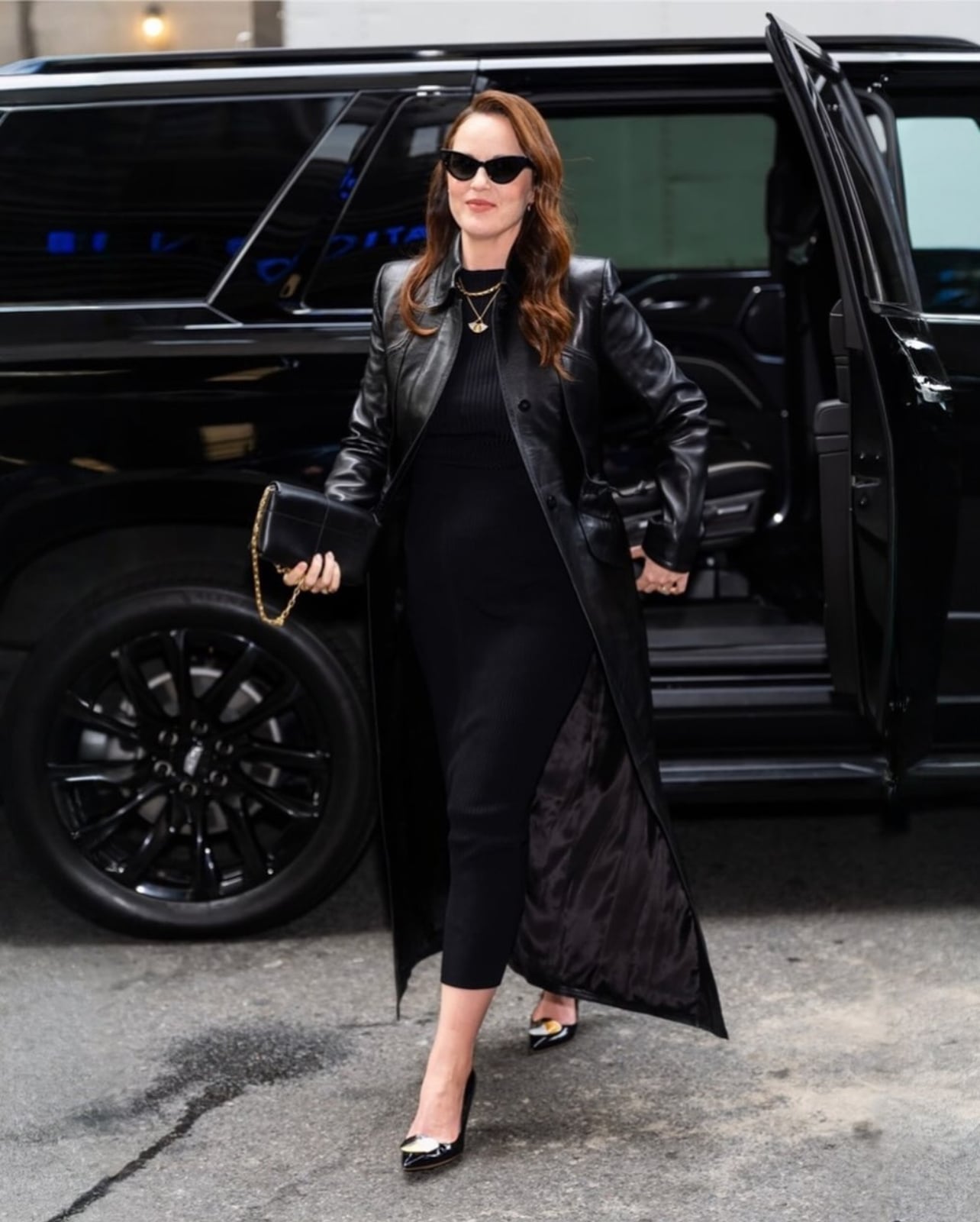 A model standing outside car wearing a black jacket