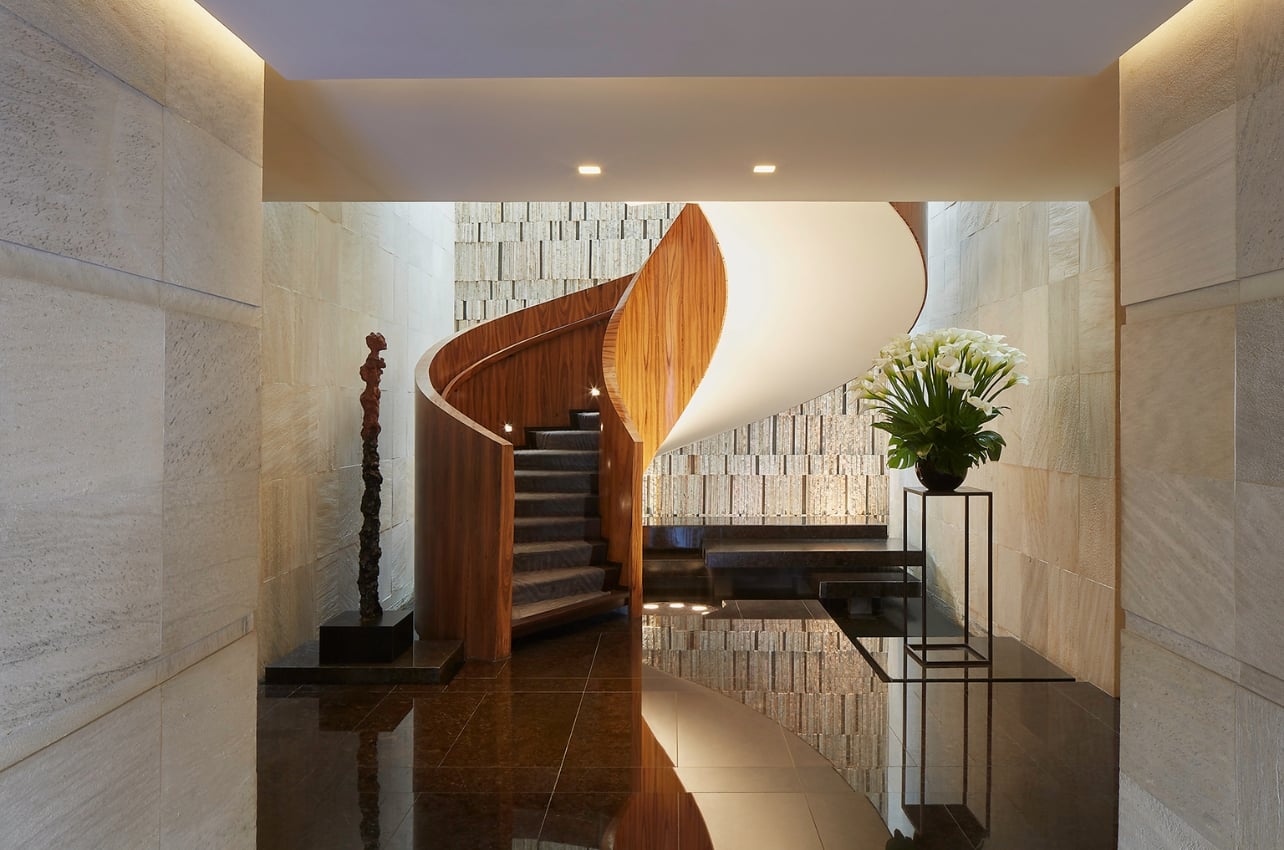 Interior shot of the wooden lobby staircases at Las Alcobas