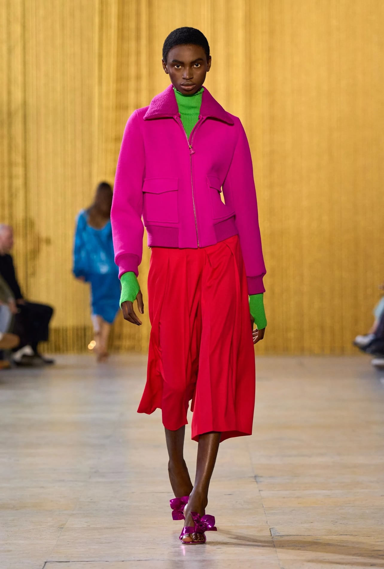 Akris runway model wearing a pink jacket and red shorts