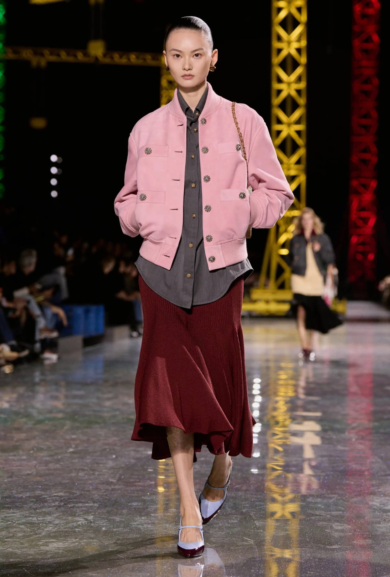 Chanel runway model wearing a pink jacket and a red skirt