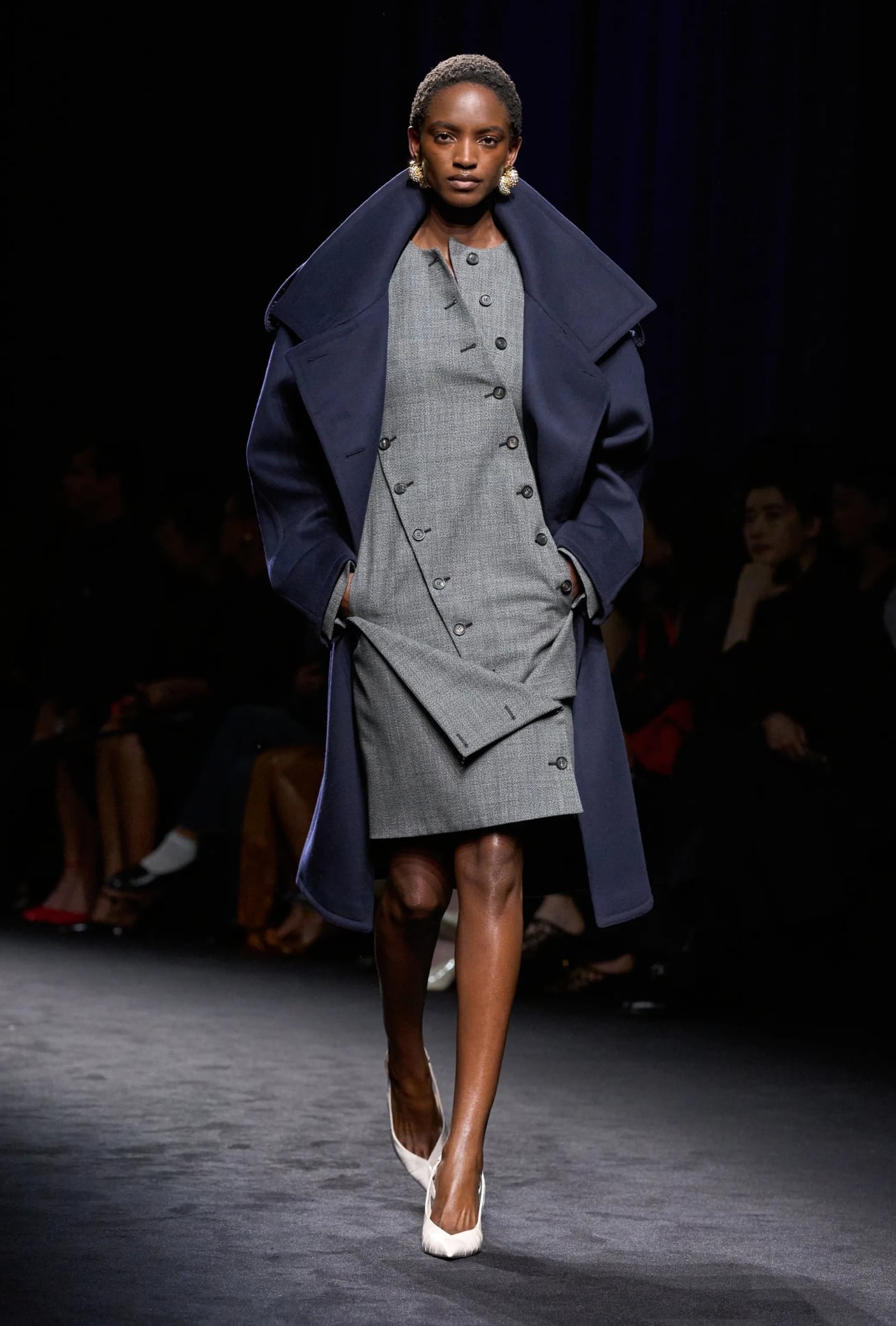 Ferragamo runway model wearing a grey dress and navy peacoat