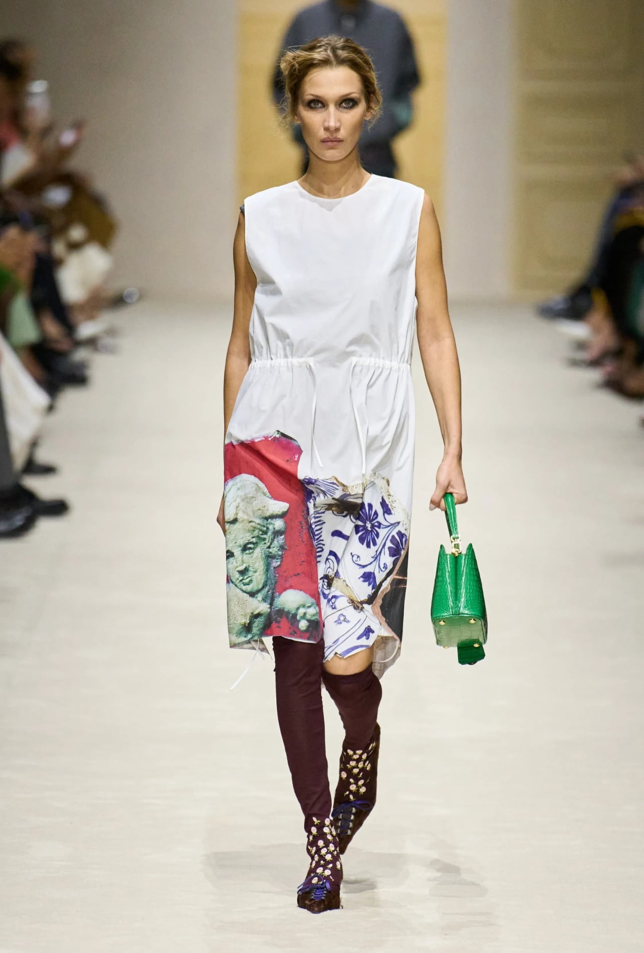 Prada runway model wearing a white dress and green purse