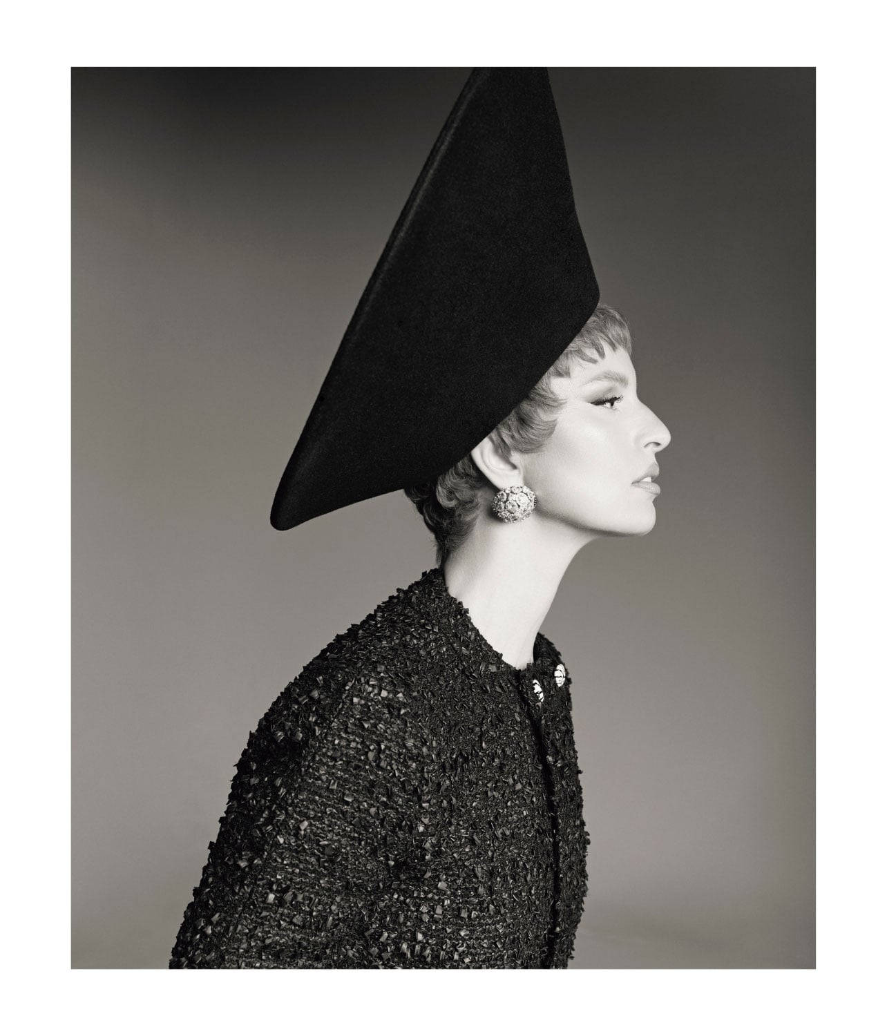 A woman wearing an abstract shaped black hat and black sweater