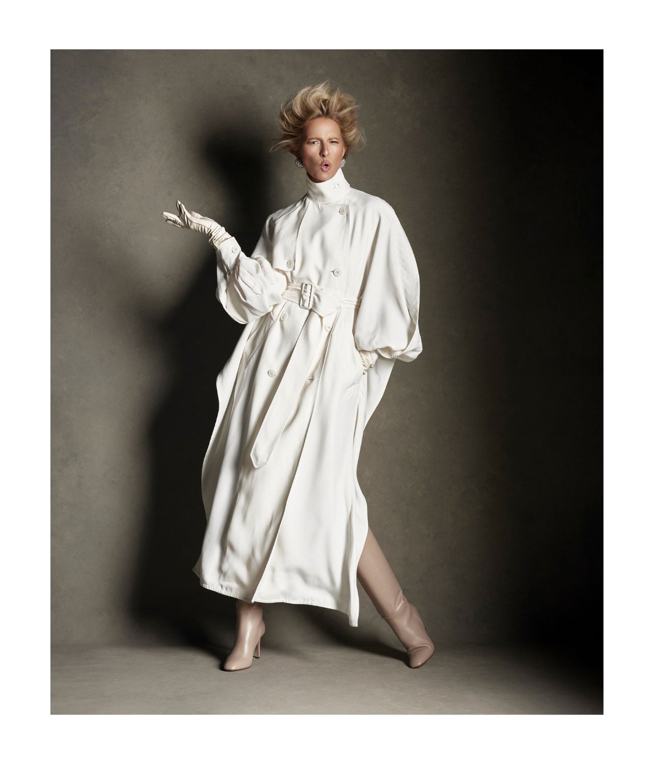 Model wearing a long coat with tall tan boots