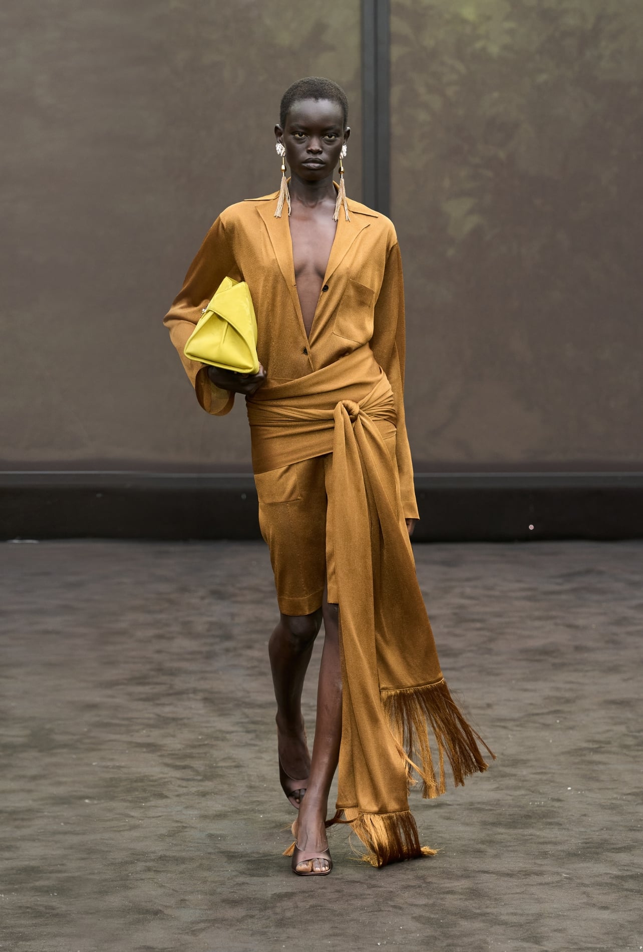 Ferragamo runway model wearing a golden dress with a fringe wrap