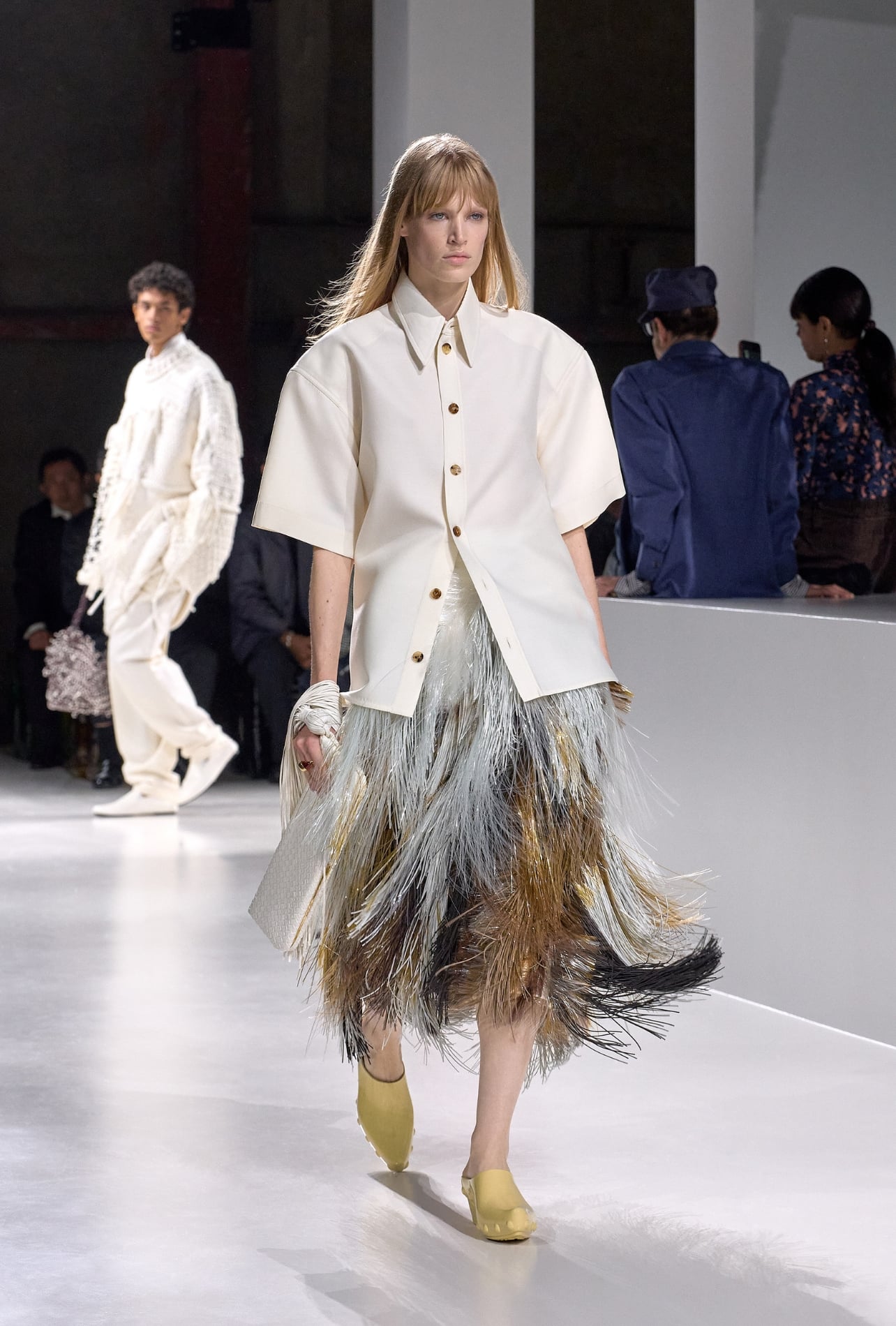 Ferragamo runway model wearing a white button-up top and fringe skirt