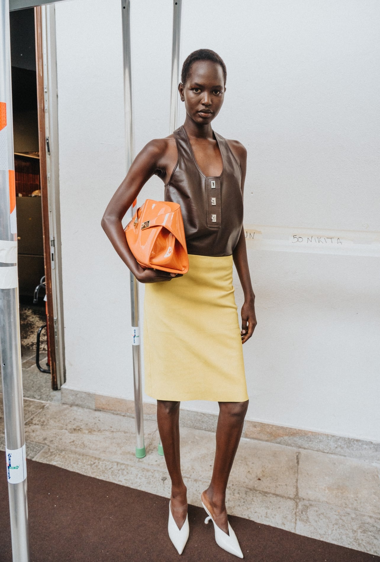 Ferragamo runway model wearing a yellow skirt and brown leather top