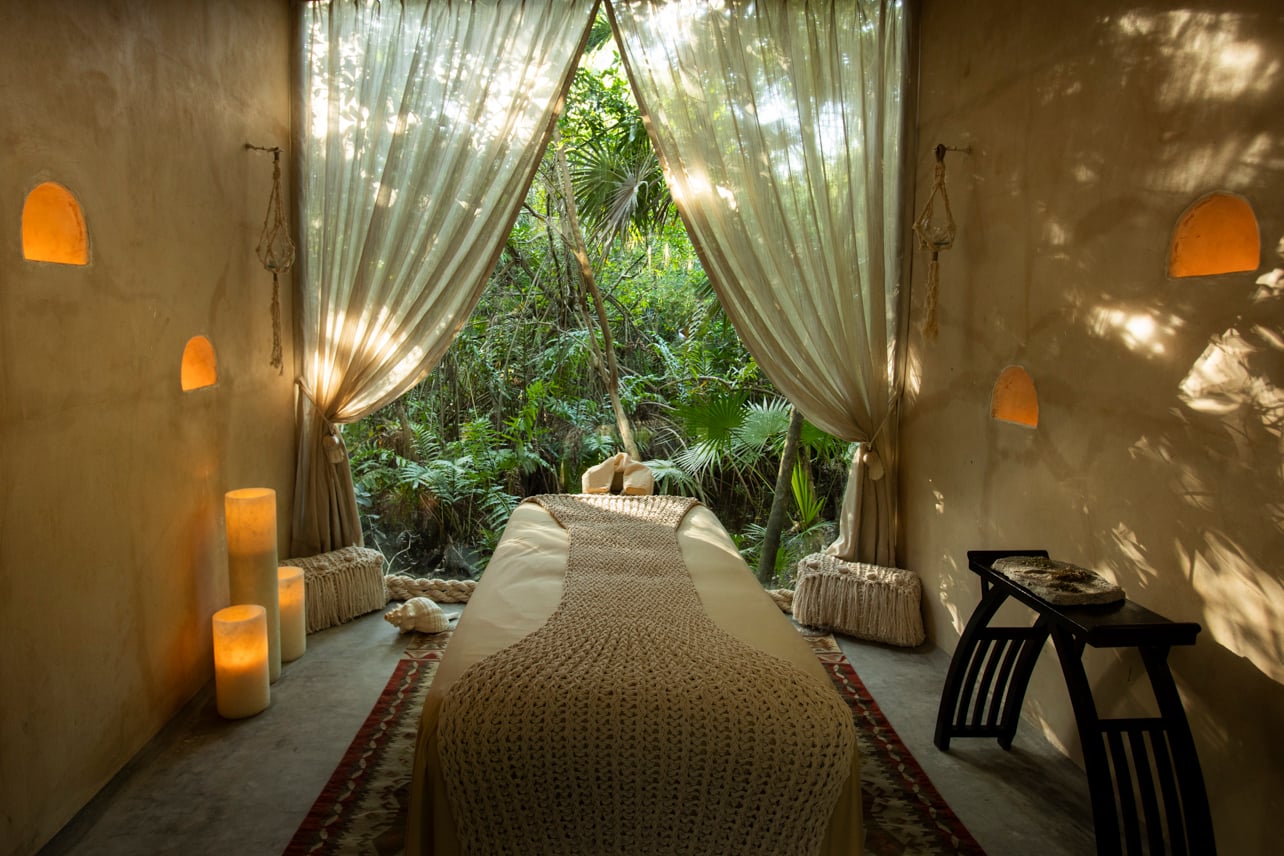 A spa room with candles set in the jungle