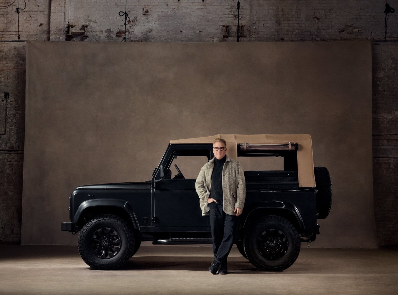 A portrait of Todd Snyder standing alongside his black car