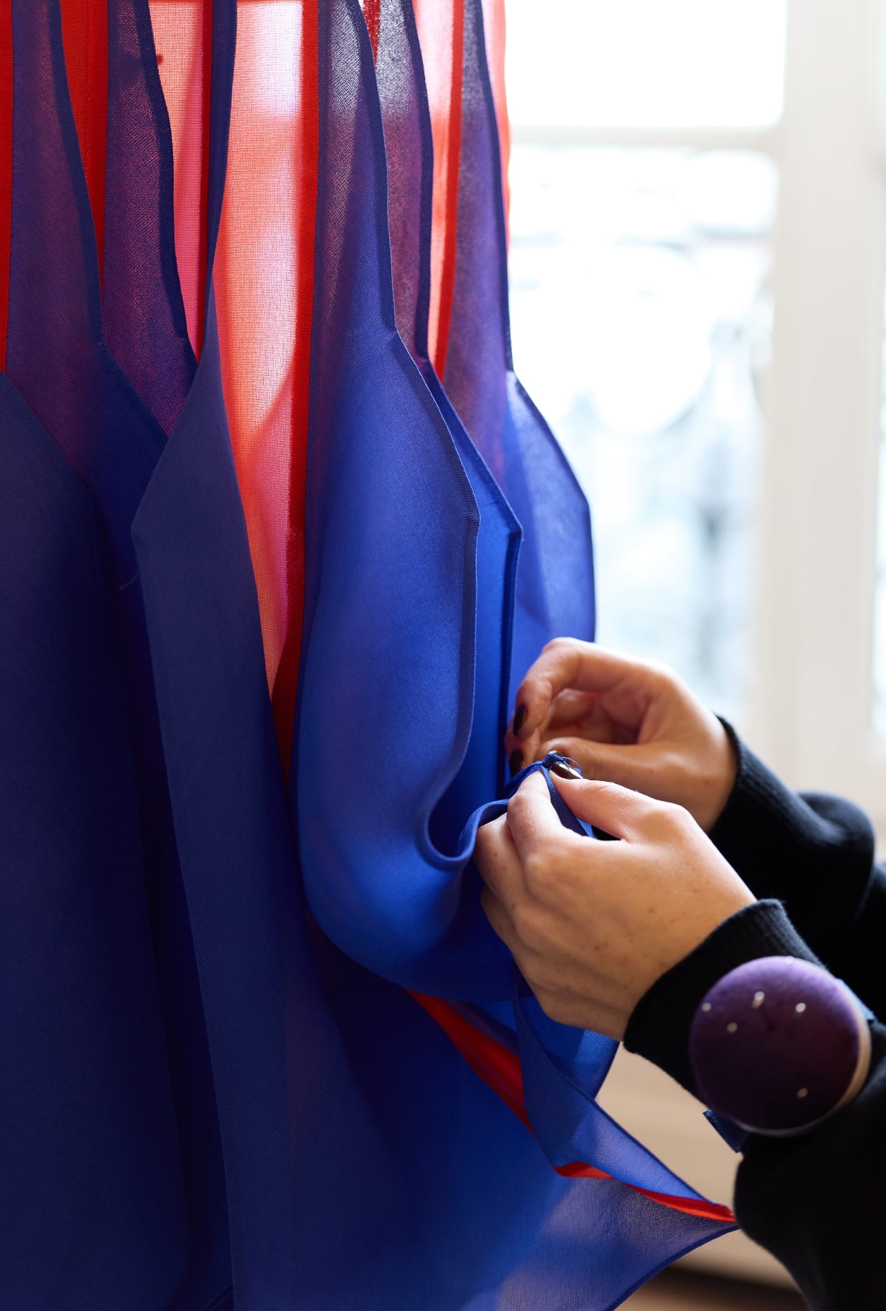 A red and blue fabric being constructed in a studio