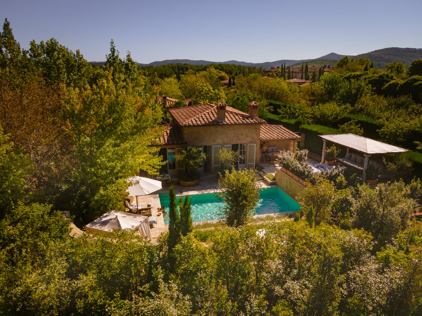 House exterior surrounded by trees and a pool at Borgo Santo Pietro