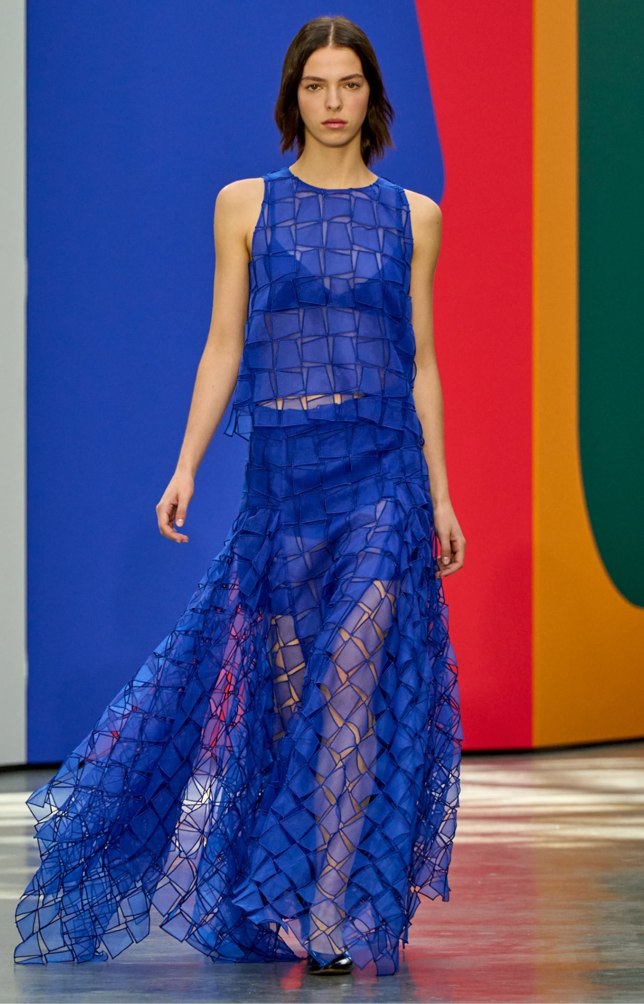 A runway model wearing a blue dress
