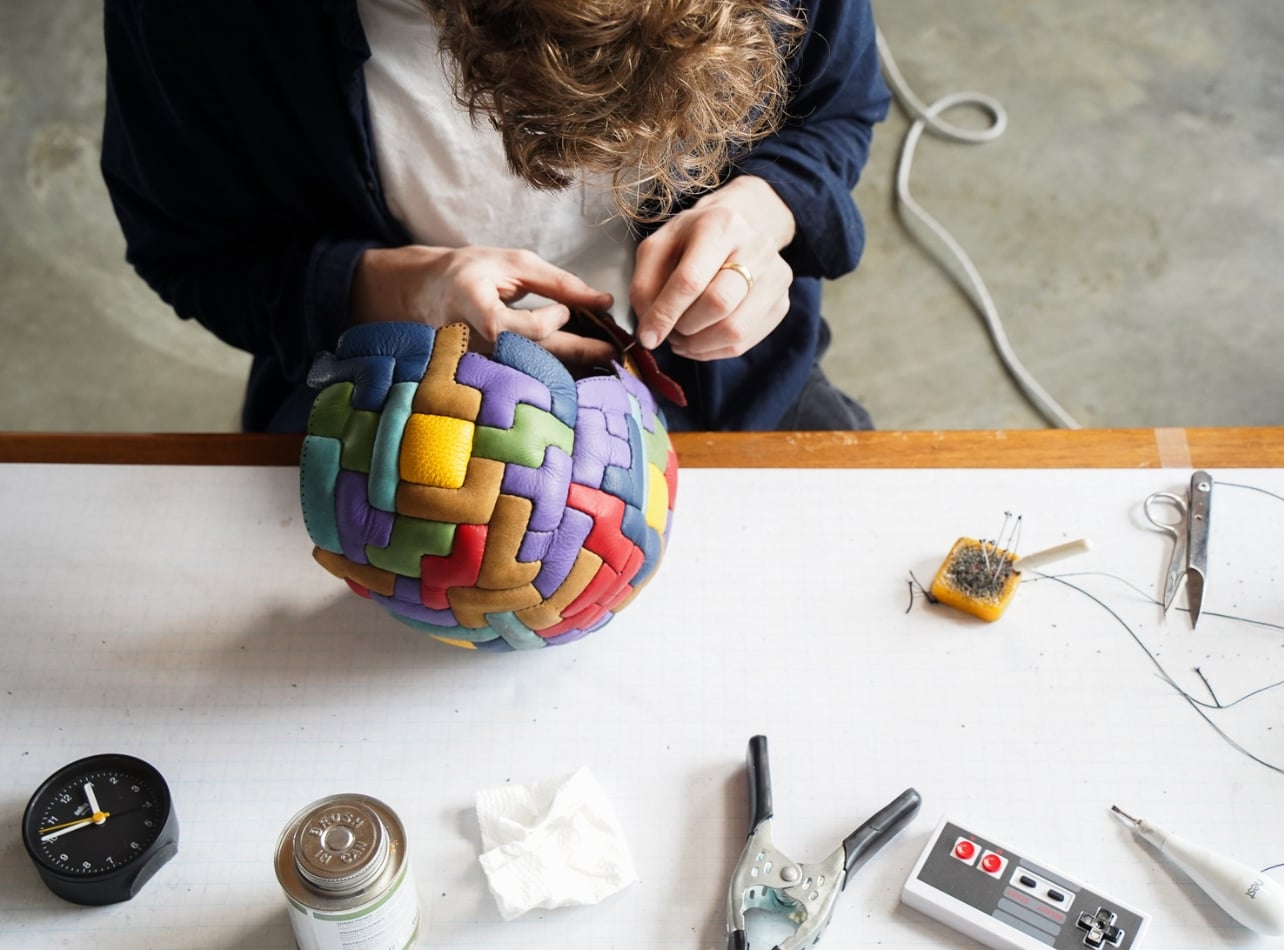 Jon Paul Wheatley sewing a multi color soccer ball