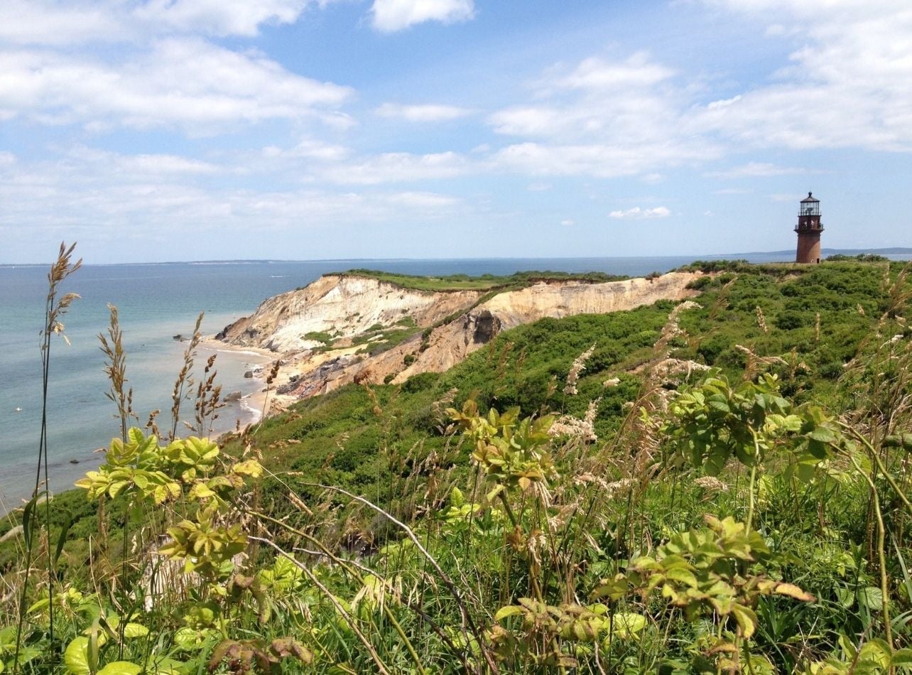 A scenic view of the blue sky, water, and cliffs in Martha's Vineyard