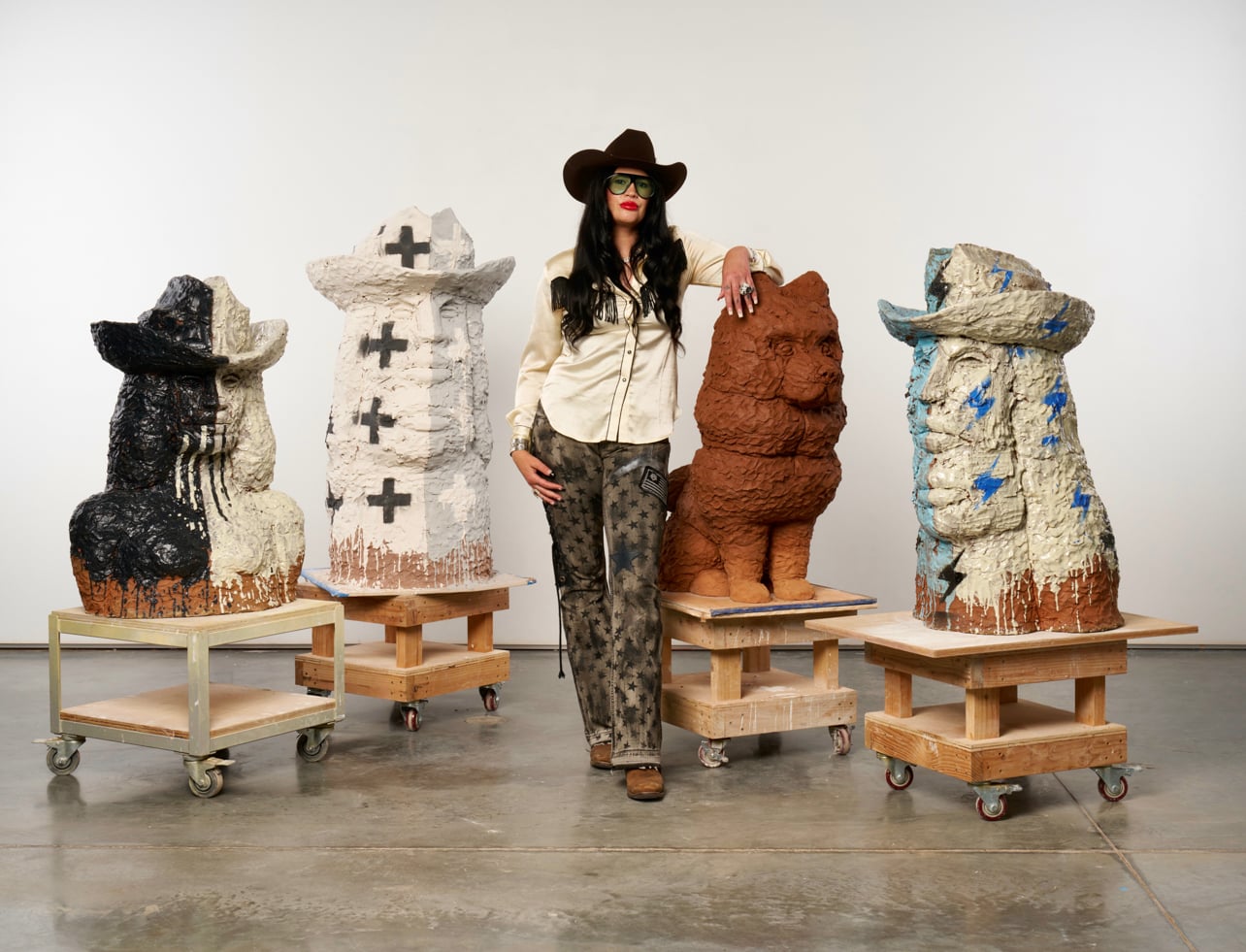 Portrait of artist Raven Halfmoon surrounded by sculptural works at Ballroom Marfa