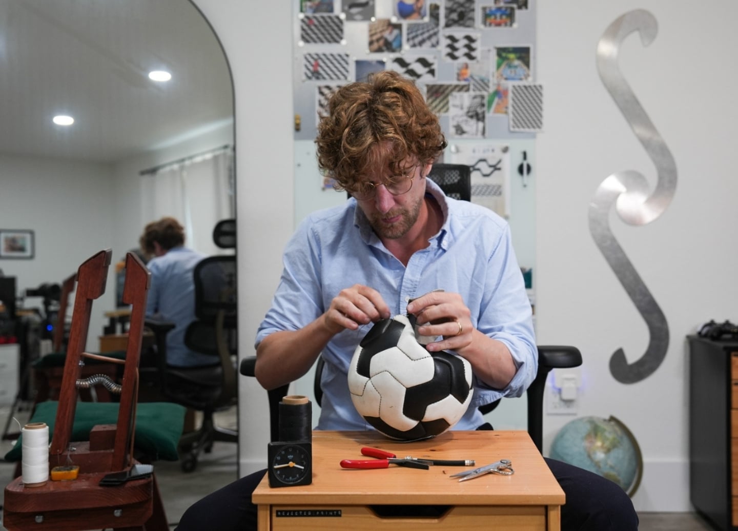 Jon Paul Wheatley sewing a white and black soccer ball