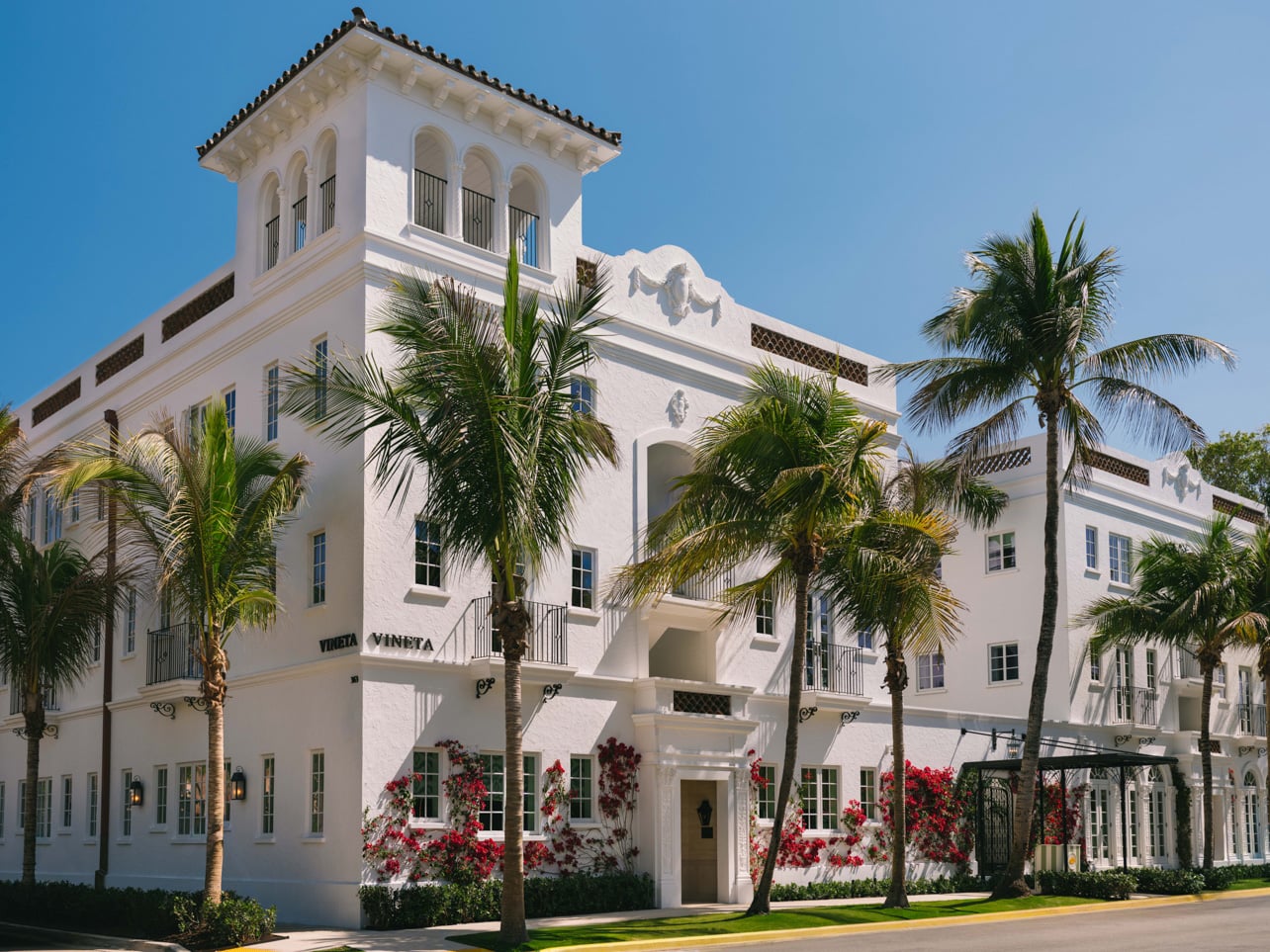 Exterior of The Vineta Palm Beach with flowers and palm trees