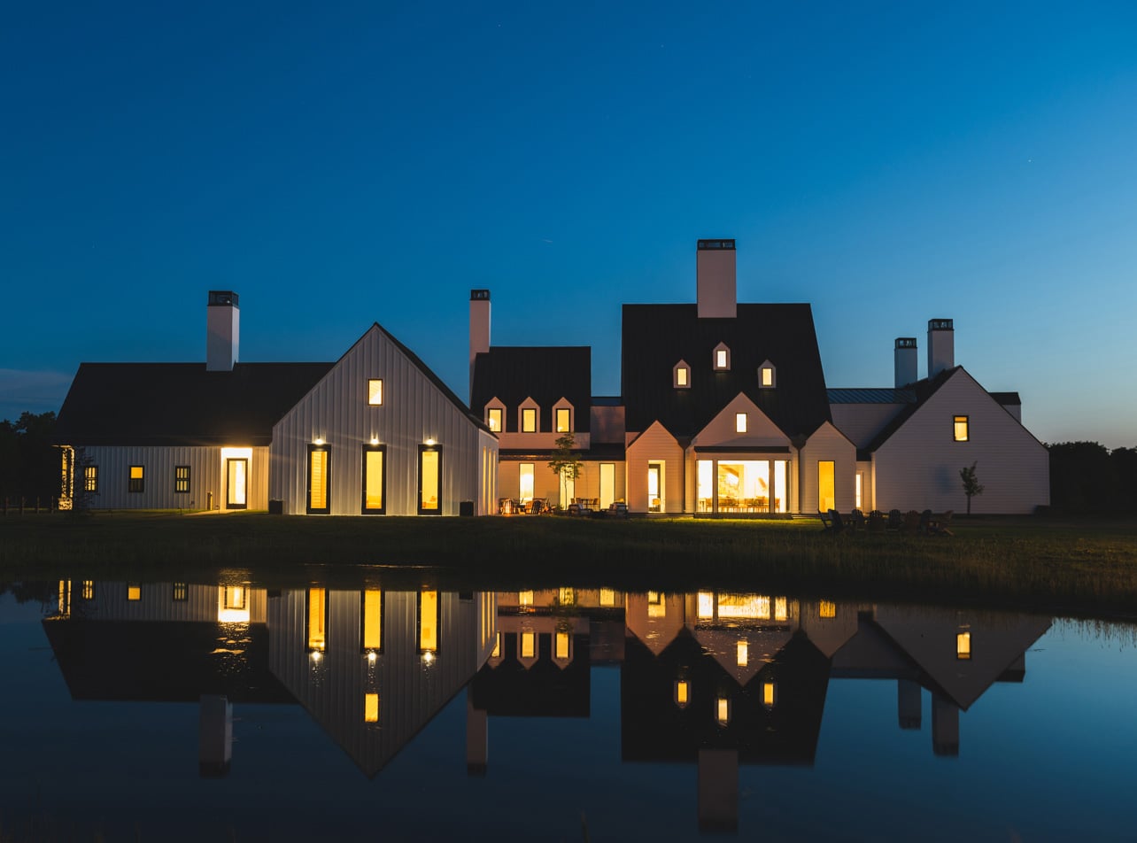 East facade of The Farmhouse at Inns of Aurora reflected at night