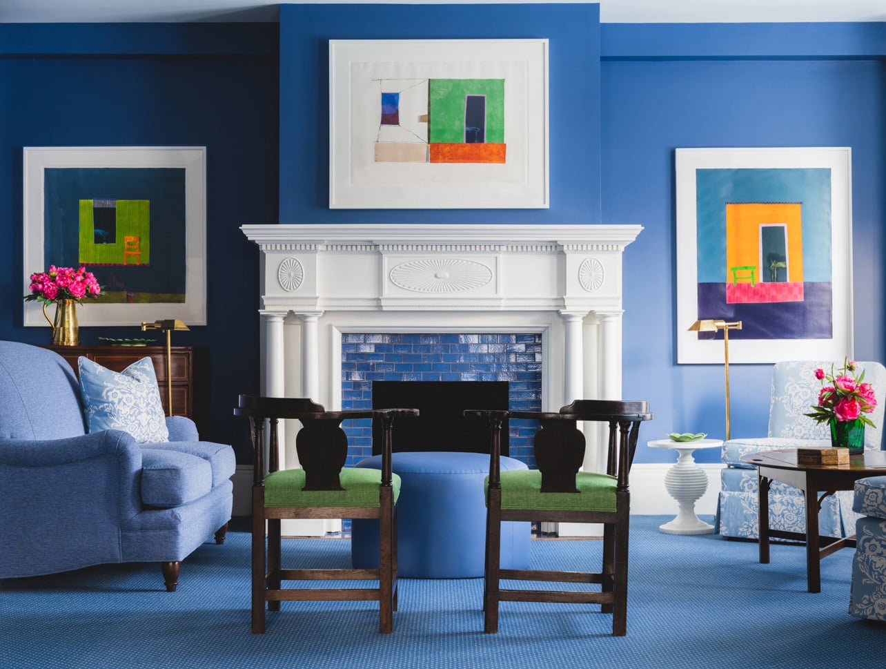 A living room with blue furniture and walls in the Zabriskie House East Parlor at The Farmhouse at Inns of Aurora