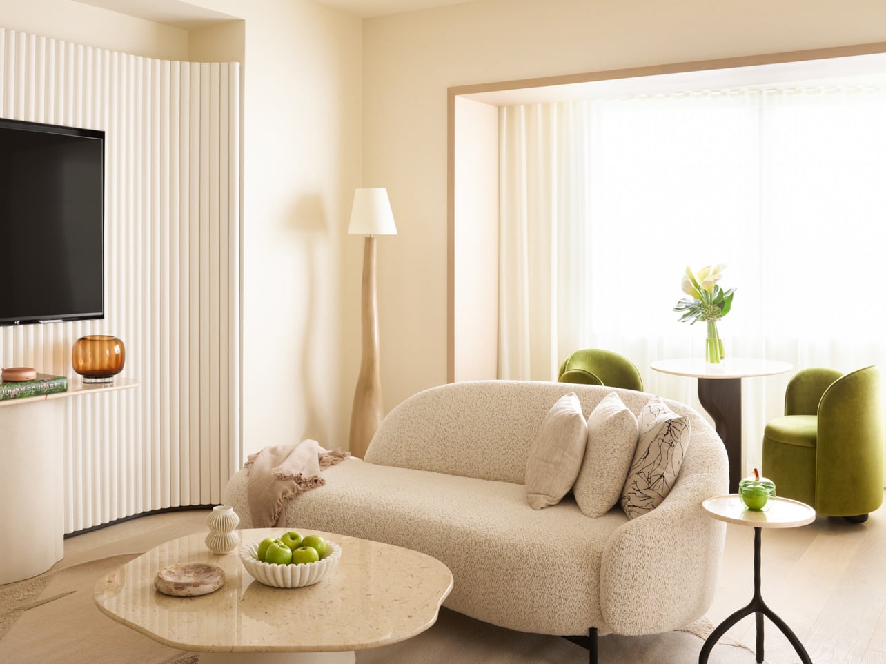 A bright white living room with green accents at Delano