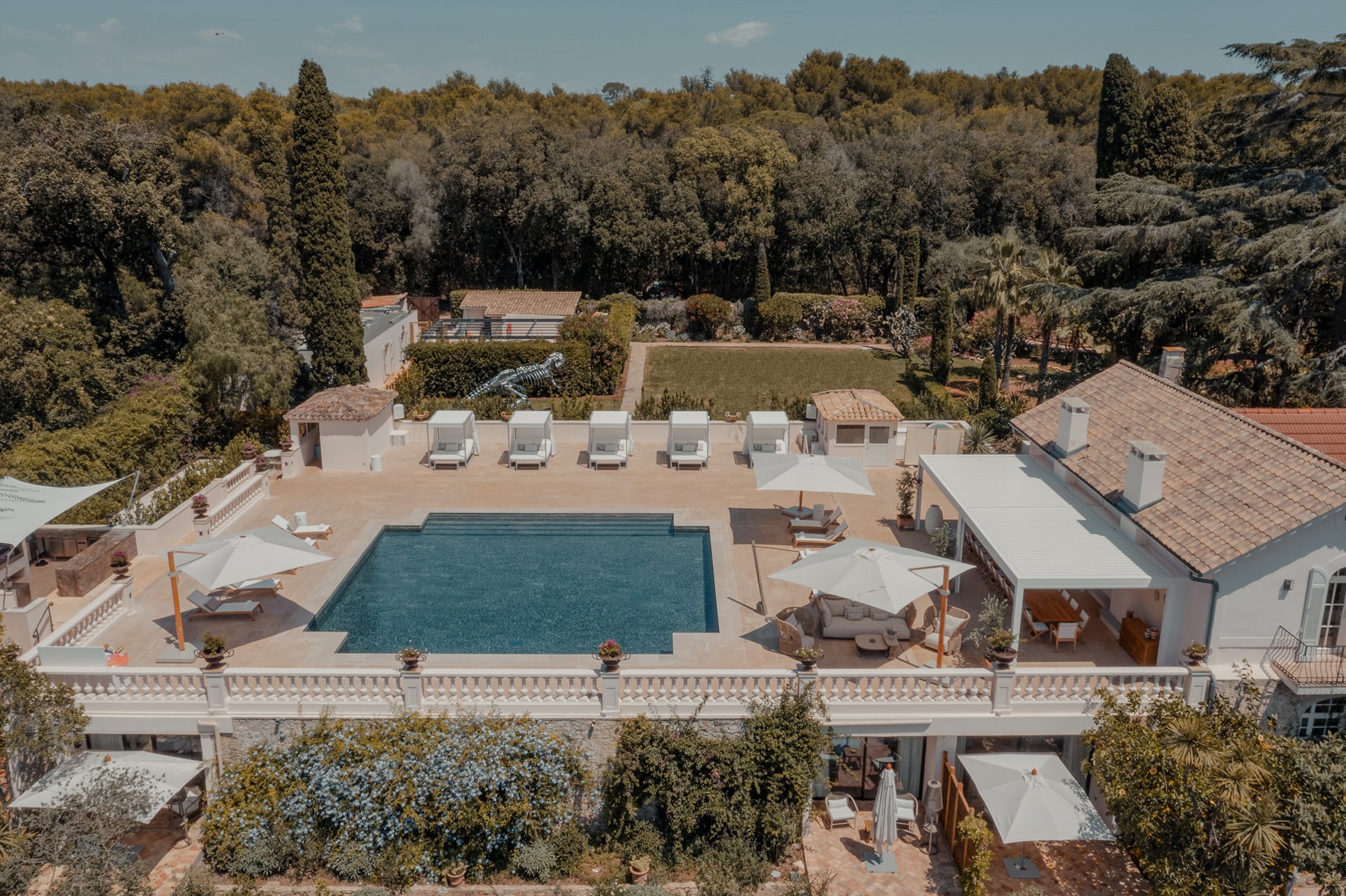 A large villa pool deck with daybeds and an outdoor lounging area