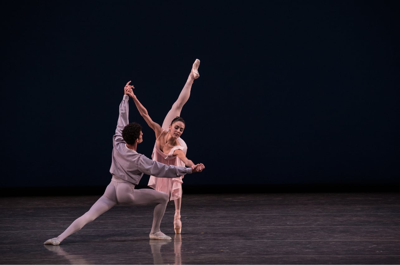 A photo of two people on stage performing ballet together