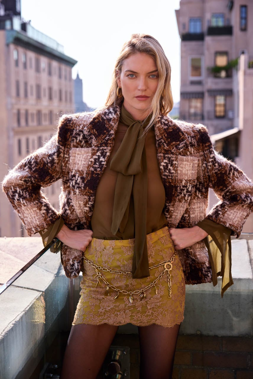 Martha Hunt photographed on a rooftop wearing a gold Saint Laurent skirt