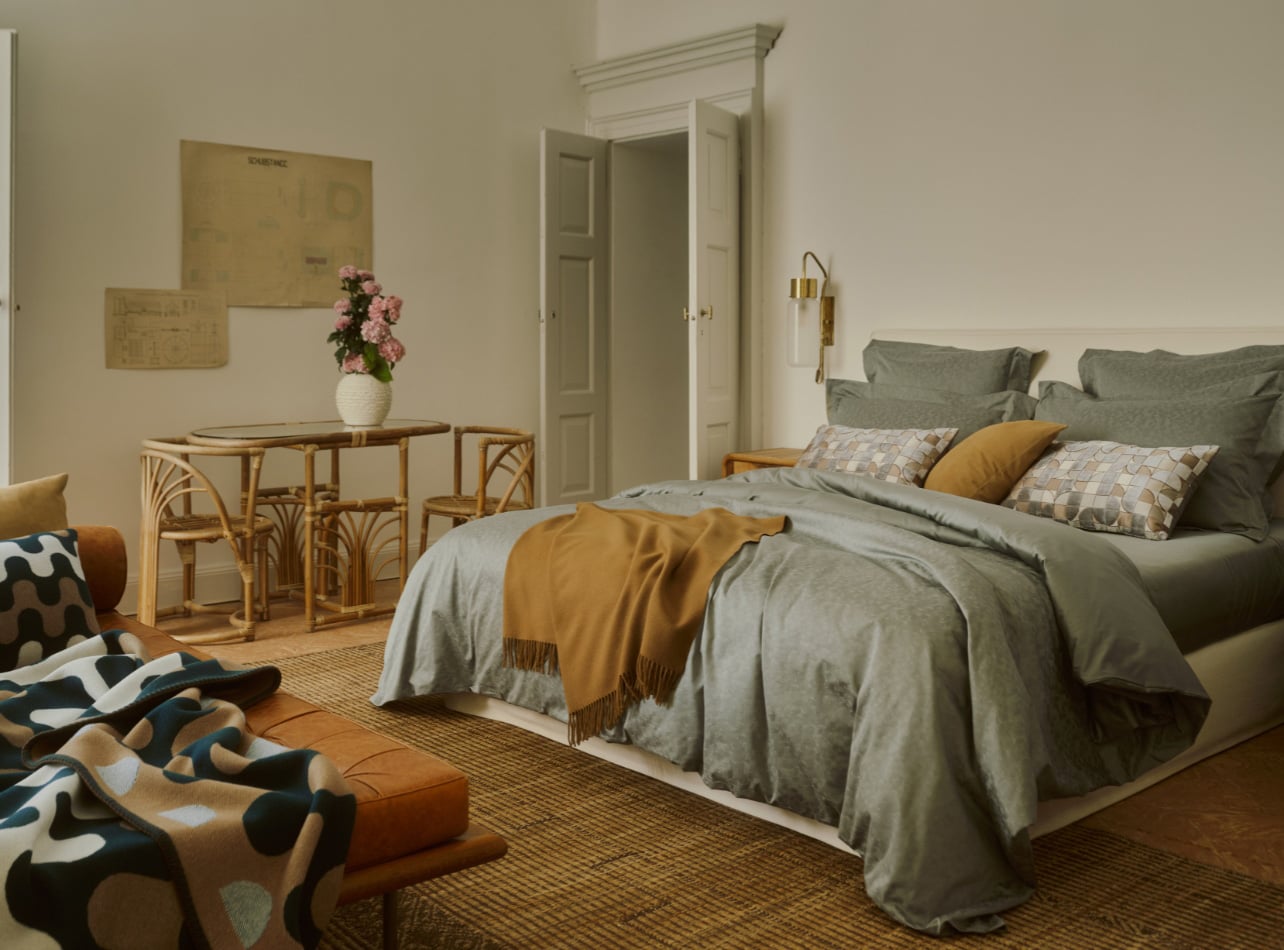 Bedroom set up with bed, table and long chair